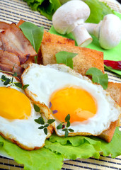 Bacon with sunny side up eggs served with toasts