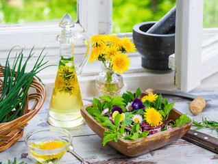 Salat aus frischen Gartenkräutern und Löwenzahn am Küchenfenster