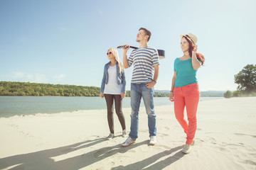 Group of young friends walking on the beach