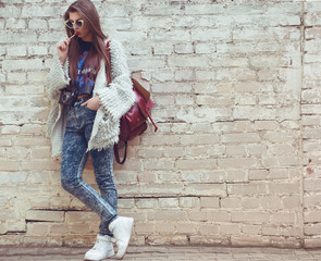 Young street fashion girl on the background of old brick wall - 82708140