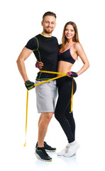 Happy athletic couple - man and woman with measuring tape on the