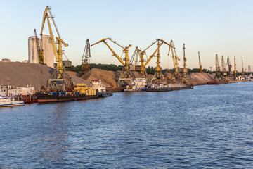 Fototapeta na wymiar barges and cranes in river port
