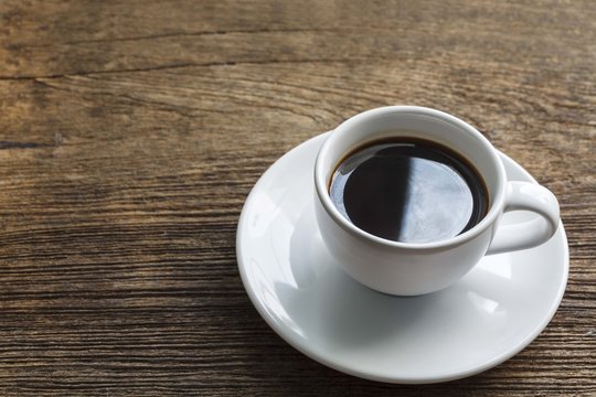A cup of black coffee on wooden