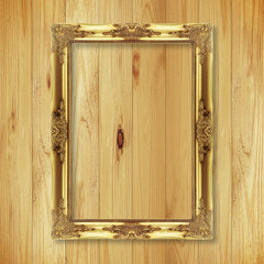 Antique gold frame on wooden wall ;. Empty picture frame on whit