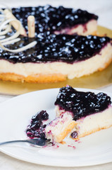 a mouthful of blueberry cheesecake