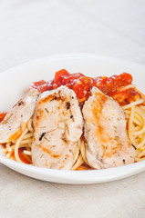 pan fried chicken breast on rich tomato pasta