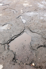 Very bad quality road with potholes and puddles