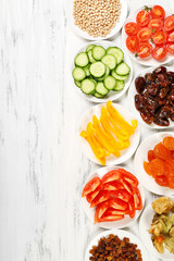Different products on saucers on wooden table, top view