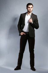 Elegant man in suit on gray background