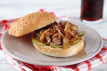 Tasty sandwich on plate and glass of cold drink, on wooden table background, close-up Unhealthy food concept
