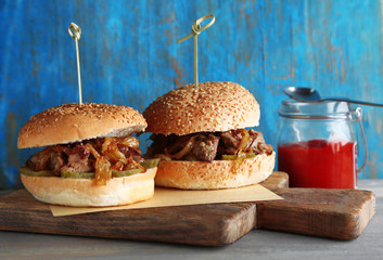 Tasty sandwich on cutting board, on color wooden background. Unhealthy food concept