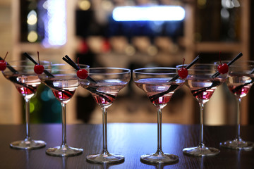 Glasses of cocktails on bar background