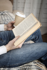 Fototapeta premium Young man reading book, close-up, on home interior background