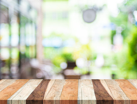 Empty tropical wood table and blurred garden cafe light backgrou