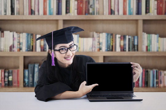 Female graduate with copy space on laptop