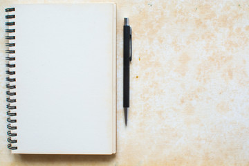 Notebook and pen on grunge background