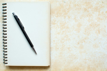 Notebook and pen on grunge background