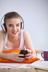 Naklejka premium Young woman lying on floor and listen to music