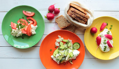 Plates with fresh cottage cheese and vegetables