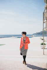 Fashion young woman standing on a embankment