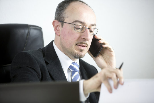 Portrait of a businessman talking on mobile phone in office