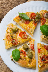Homemade pizza with cheese and tomatoes on wooden table