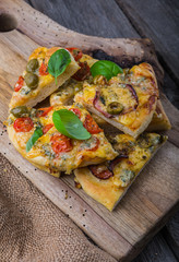 Homemade pizza with cheese and tomatoes on wooden table