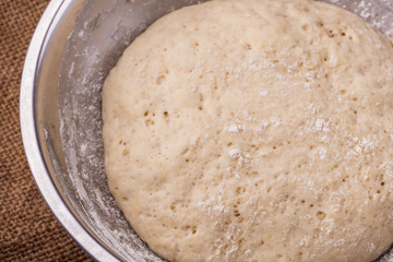 Sourdough yeast dough rises in a bowl on the table