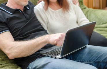 Couple sitting on a sofa using a computer