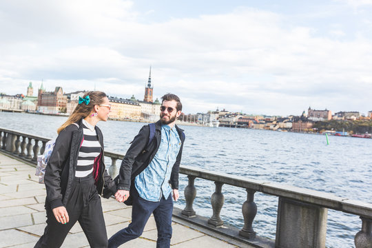 Young hipster couple running hand in hand in Stockholm