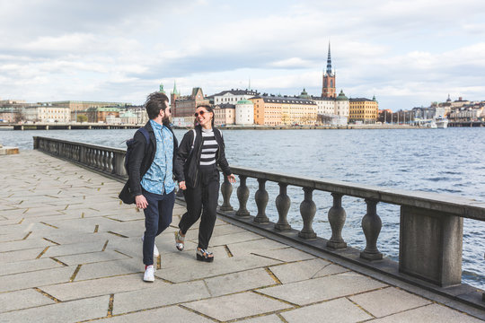 Young hipster couple running hand in hand in Stockholm
