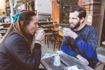 Hipster couple drinking coffee in Stockholm old town.