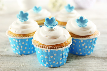 Delicious cupcakes on table on light background