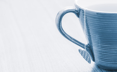 Tea mug on rustic wooden table with heart shaped label