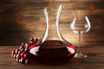 Glass carafe of wine on wooden background