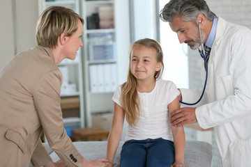 Fototapeta premium Little girl at doctor's office with mommy