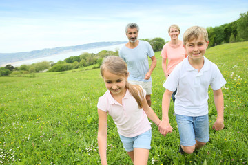 Family of four running in countryside
