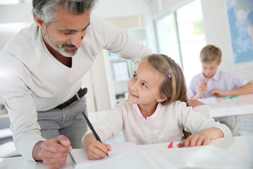 Obraz premium Teacher with schoolgirl in class