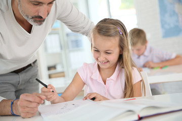 Obraz premium Teacher with schoolgirl in class