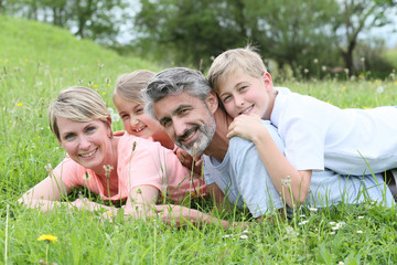 Fototapeta premium Portrait of family laying down in grass