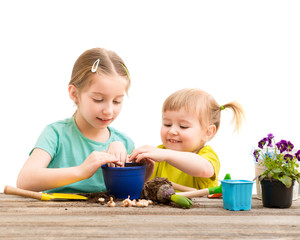 Two little sisters are engaged in gardening