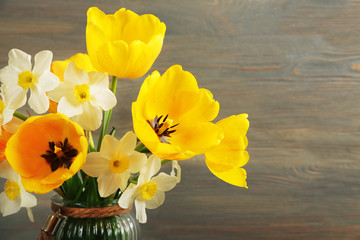 Beautiful bouquet of tulips and narcissus on wooden background