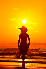 young woman on the beach in summer sunset