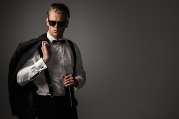 Sharp dressed man in black suit with bottle of wine