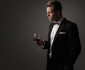 Confident sharp dressed man with glass of wine