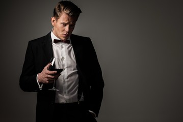 Confident sharp dressed man with glass of wine