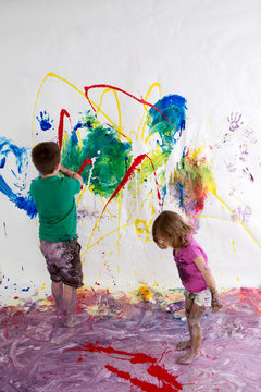 Young brother and sister painting together