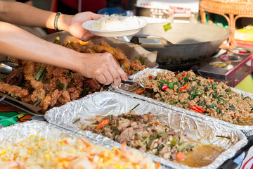 close up of hands with wok at street market