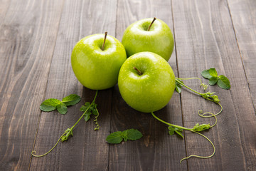 Ripe green apples on wooden background