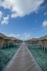 Fototapeta na wymiar Over water resort in Maldives with blue sky